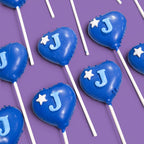 Blue heart-shaped Cake Pops with 'J' and white stars.