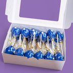 Box of blue heart-shaped Cake Pops with 'J' and white stars.