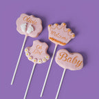 Four Cake Pops with baby girl shower themed text and designs.