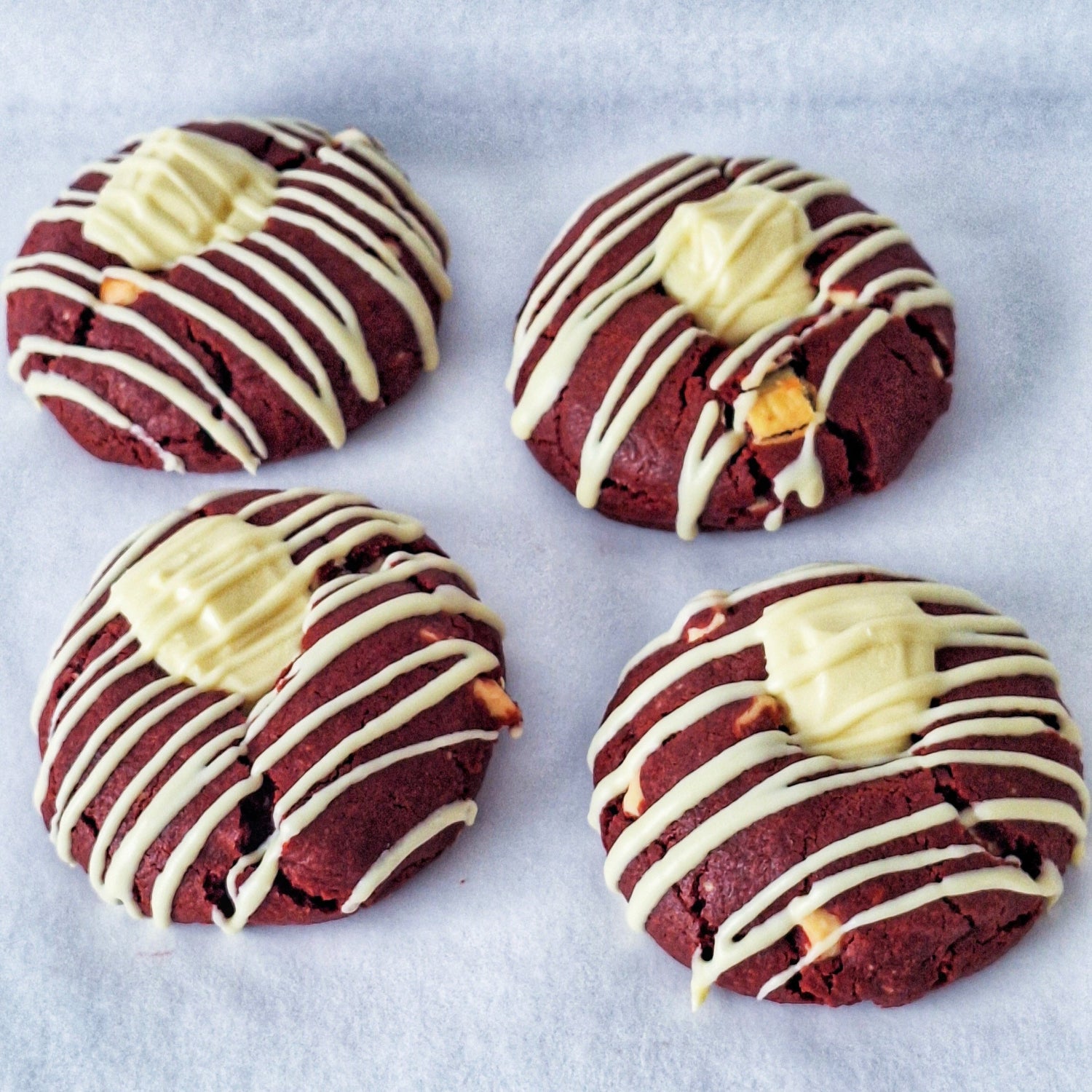 Four red velvet cookies with cream cheese