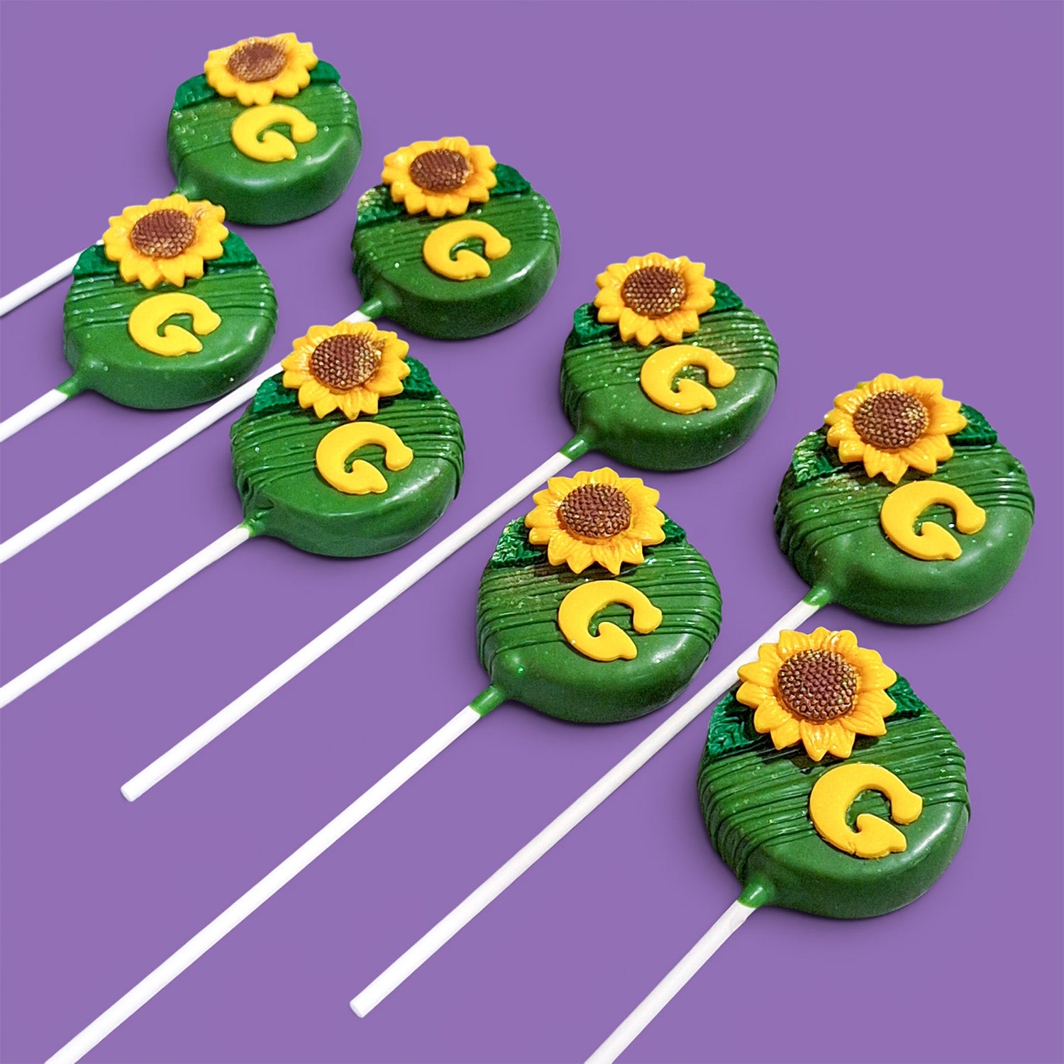 Green Rounded Shape Cake Pops with sunflower decorations and letter "G".