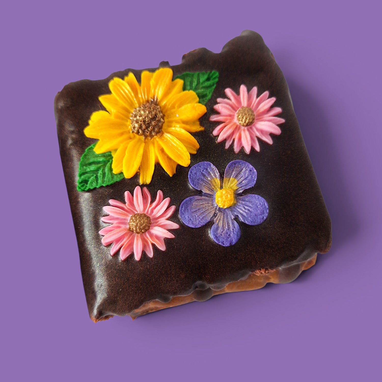 Option 2 Brownie cake and caramel with colourful flower decorations on a chocolate sauce top view.