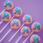 Pink Rounded Cake Pops with blue and purple heart decorations.