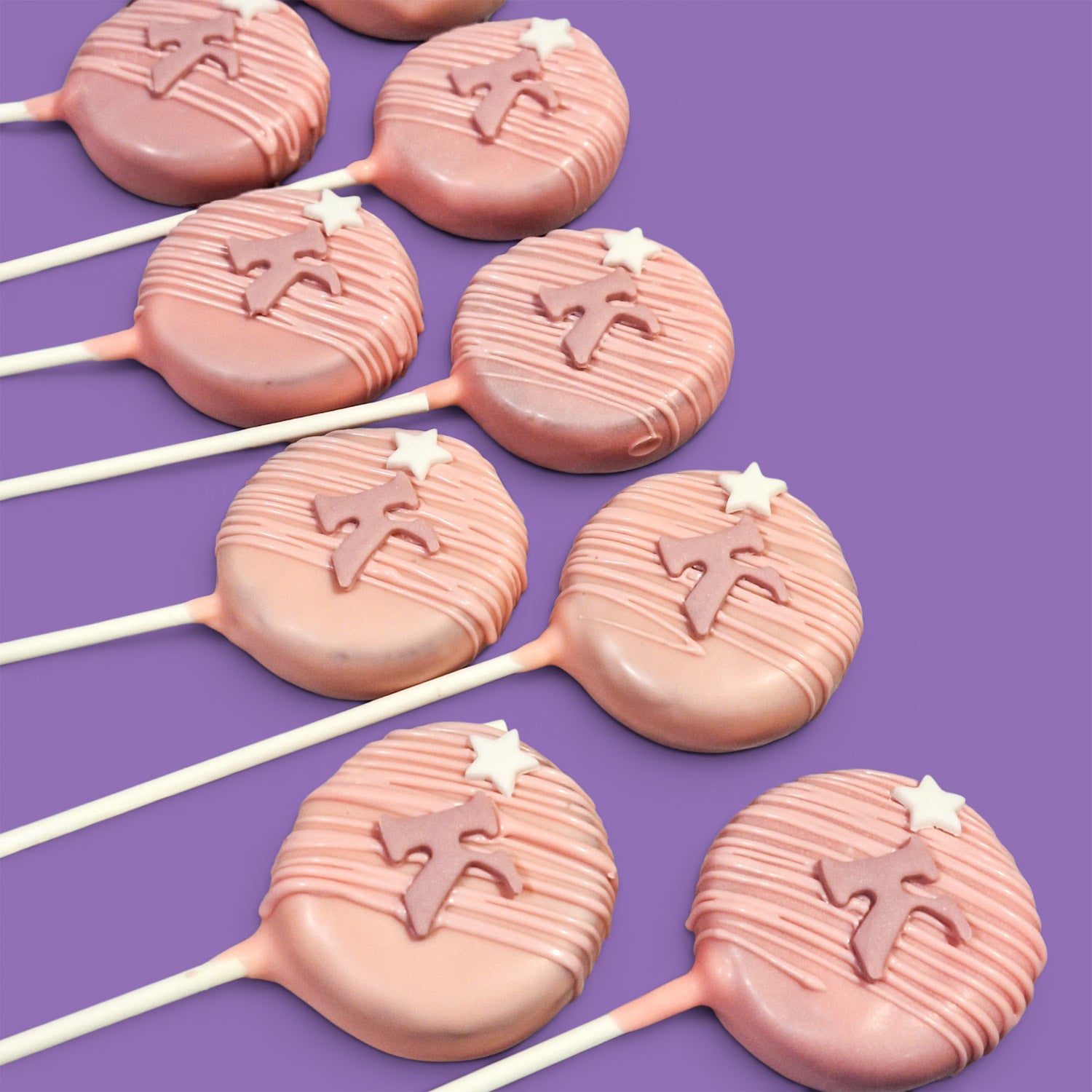 Pink Rounded shape Cake Pops with star and Letter "K" decorations.