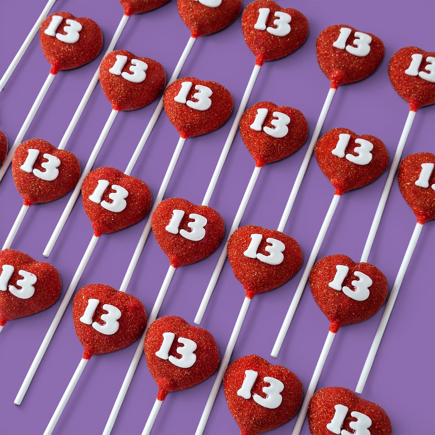 Red heart-shaped Cake Pops with the number 13 on white.