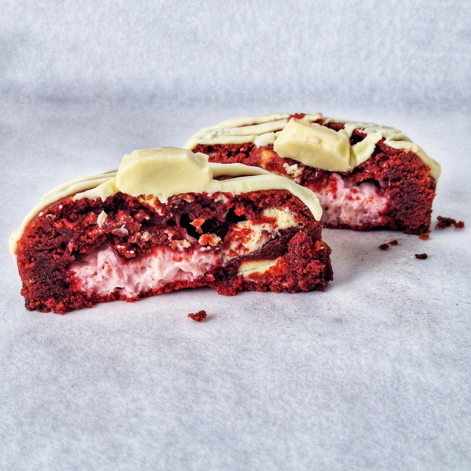 Red velvet cookie with cream cheese filling and white chocolate drizzle