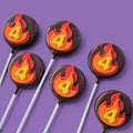 Rounded Cake Pops covered in dark chocolate with flame design and number 4.